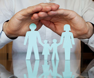 Paper cut-out covered with hands, representing insurance coverage Paper cut-out covered with hands, representing insurance coverage